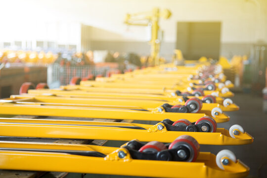 Row of yellow forklift forks with wheels in factory