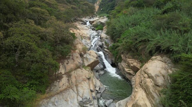 Aerial drone video of the rocky river and crystal-clear waters of the waterfalls, near the Laquipampa Wildlife Refuge, Lambayeque, Peru.