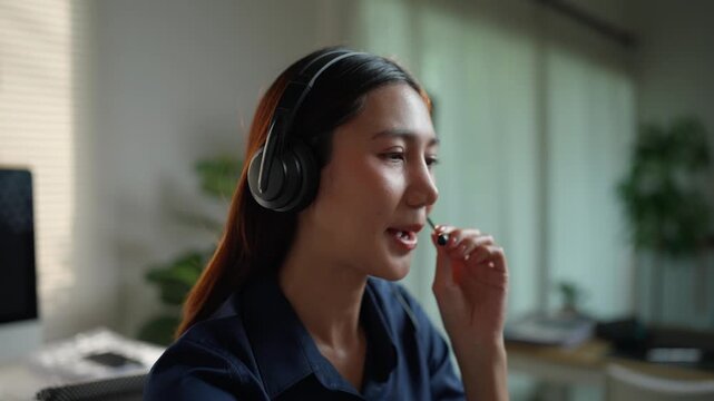 Professional female operator wearing a headset working in customer service. A smiling telemarketing representative consulting a client online