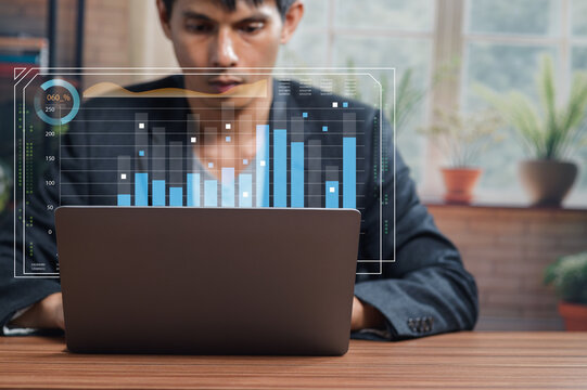 Businessman Analyzing Data Trends on Laptop with Charts Displayed