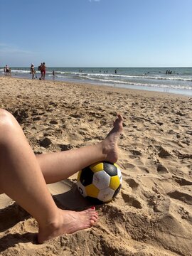 Soccer ball on sandy beach during summer seaside vacation