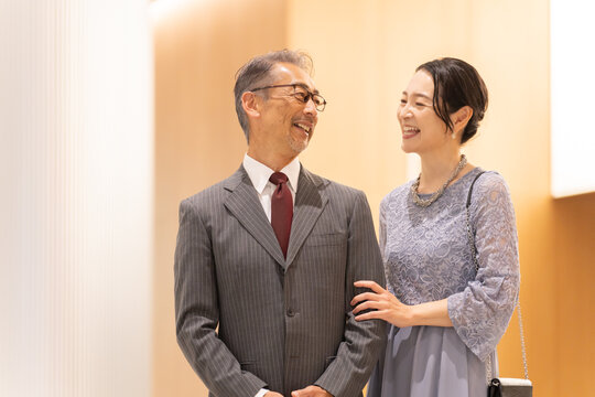ホールの前に立つフォーマルな中高年夫婦