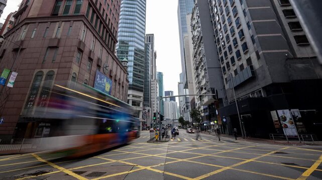 Time lapse of city street intersection with traffic and skyscrapers in central business district of Hong Kong.