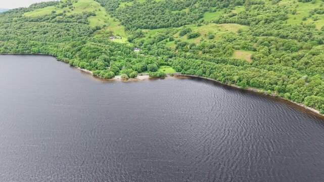 Beautiful aerial view of Firkin Point at Loch Lomond, Scottish Highlands. Scenic aerial shot of the textured lake water and lush green hills along the shoreline.