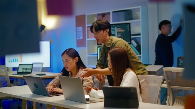 group of Happy young asian business people chatting happily after a night of overtime work in the office.Supervisor chats with employees after working together planning success strategy enjoy teamwork