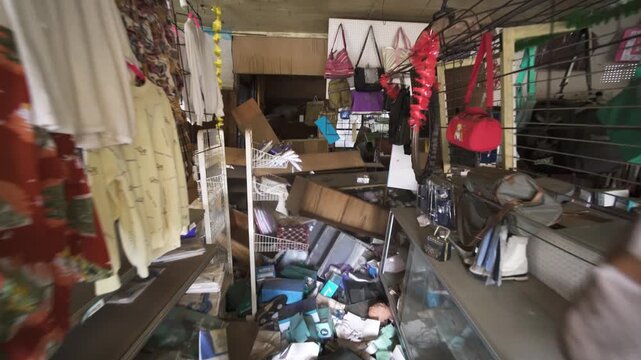 Slow push-in shot of a chaotic, abandoned clothing store in Fukushima, Japan.