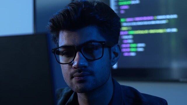 Close-up of male programmer wearing glasses with reflection of financial data chart and coding, Concept of data analysis, software engineering, cybersecurity, stock market trading and business network