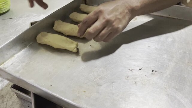 Baker Arranging Dough on Baking Sheet