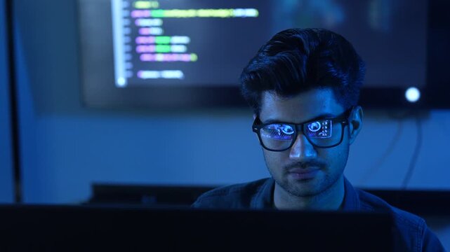 Close-up of male programmer wearing glasses with reflection of financial data chart and coding, Concept of data analysis, software engineering, cybersecurity, stock market trading and business network