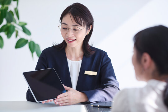 タブレット端末を使い接客をする女性