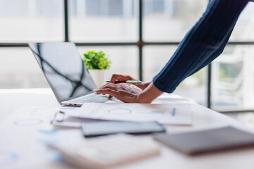 Professional hands interacting with laptop keyboard, analyzing business data and financial...