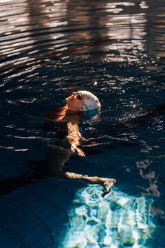 Woman swimming on her back in pool