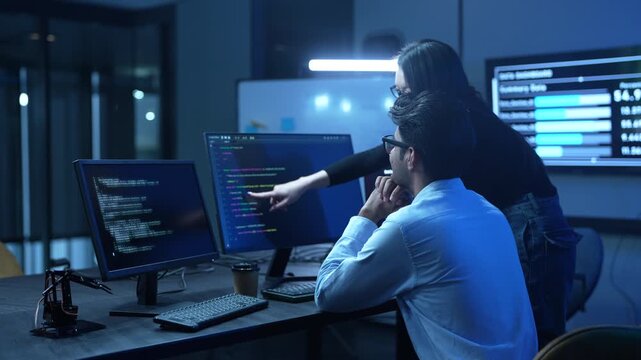 Professional IT specialist and programmer working on software development, Male developer talking with female colleague about computer code, Modern coding team and technology collaboration concept