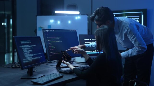 Professional IT specialist and programmer working on software development, Male developer talking with female colleague about computer code, Modern coding team and technology collaboration concept