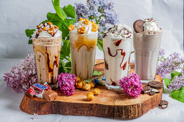 Obraz premium Delicious milkshakes with whipped cream and toppings beautifully arranged on a wooden platter