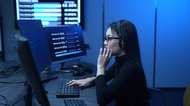 Customer service, asian female IT support engineer wearing headset working on computer code, technical helpdesk, call center, software development, cybersecurity and global corporate communications