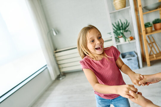 Portret of brother and sister having fun dancing together at home