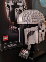 Fototapeta premium Rome, Italy - June 10, 2026, Mandalorian helmet from the Star Wars series with the box next to it, produced by Lego, inside a toy store.