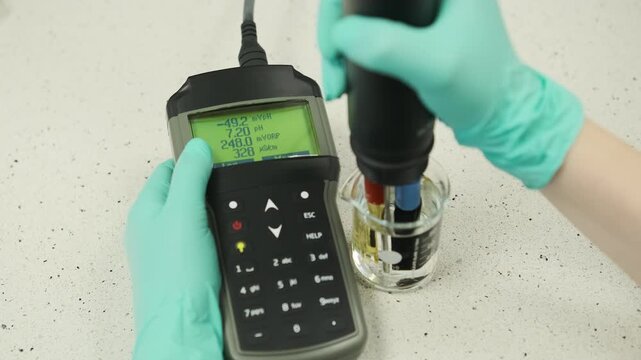 Close up laboratory footage of water analysis using a multifunction pH and conductivity meter. Scientific measurement of water quality parameters, analytical chemistry testing, environmental