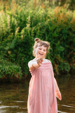 Young girl showing a stone she found while exploring a stream