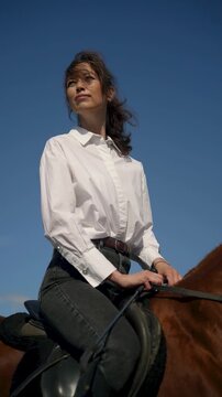 Woman in white shirt on horseback