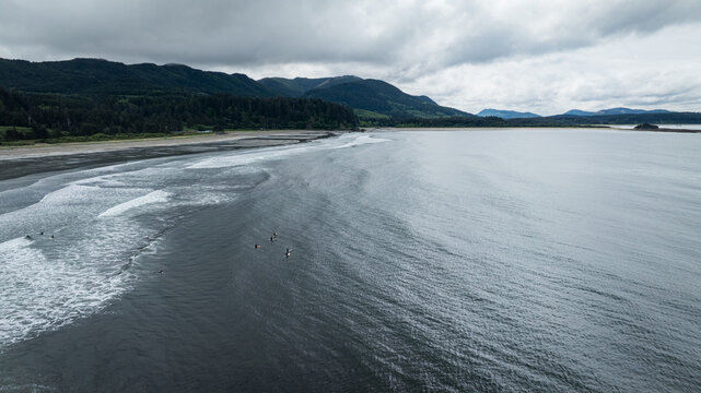 Surfers dot the water on a remote moody coastline Washington PNW