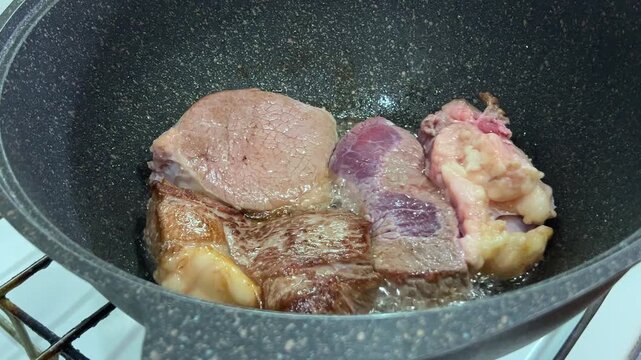 Raw Beef Chunks Boiling in Pot on Stove, Close-Up