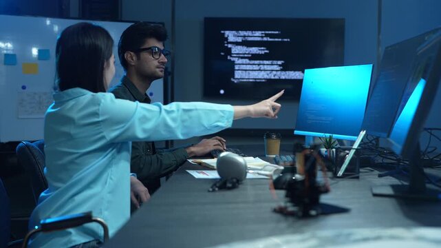 Professional IT specialist and programmer working on software development, Male developer talking with female colleague about computer code, Modern coding team and technology collaboration concept