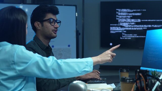 Professional IT specialist and programmer working on software development, Male developer talking with female colleague about computer code, Modern coding team and technology collaboration concept