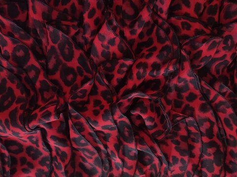 Texture de tissu l&eacute;opard rouge et noir avec plis &ndash; motif animalier audacieux et tendance