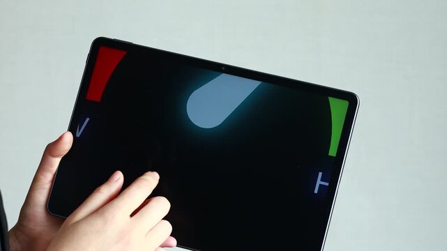 A hand touches a digital tablet that displays a risk gauge. The gauge shows levels from low to high, using colors to indicate the risk presented. The setting appears modern and minimal.