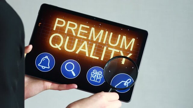 A person holds a tablet showing a premium quality sign with stars and icons. This activity takes place indoors, likely during a tech event or presentation.