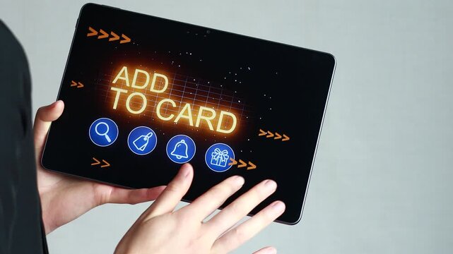 A hand presses buttons on a tablet screen that displays options for adding items to a cart. The user engages with digital shopping features in a modern setting.