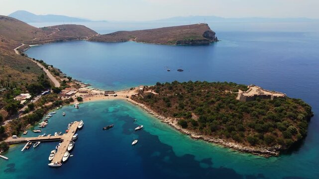 aerial view of a secluded sandy beach and turquoise shores in Porto Palermo bay, Albania. Mediterranean coastal landscape with crystal clear waters