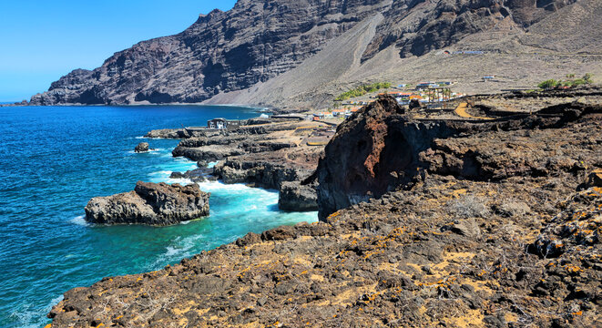 Volcanic west coastline with ocean waves and village, Island El Hierro, Canary Islands, Spain, Europe.
