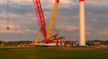 Obraz premium Installation of wind turbines using a massive mobile crane in a spring field
