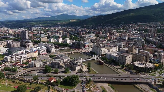drone view of the historic Skopje Fortress walls running along the hillside next to the Vardar river and city traffic in North Macedonia