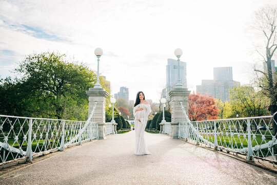 Pregnant woman posing on bridge in boston public garden