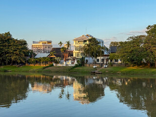 Fototapeta premium Riverside buildings reflecting in the water in Chiang Mai