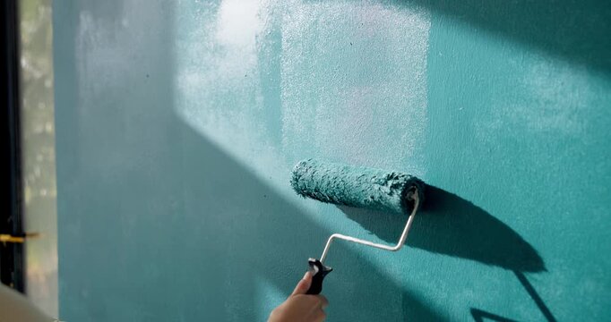 Person, hand and paint for renovation in home, upgrade and interior design with improvement. Paintbrush, equipment and remodeling with DIY project, maintenance and color for wall and process