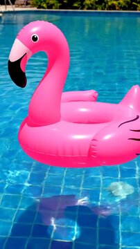 Pink inflatable flamingo float on clear blue swimming pool water surface