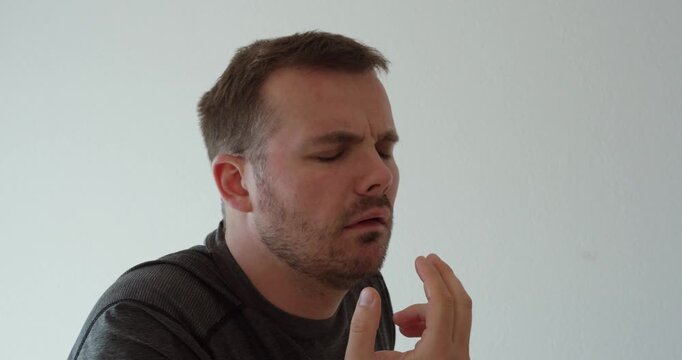 Side view of a man reacting to nausea and gag reflex discomfort, representing stomach illness, sickness, digestive problems, vomiting sensation, health issues, and physical discomfort.