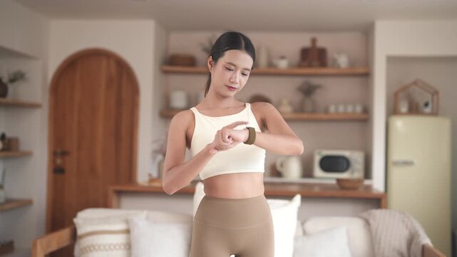 Fitness woman look at smartwatch checking heart rate, calories burned, tech in home gym, fitness, health tracking, self care, technology and healthy living, digital wellness