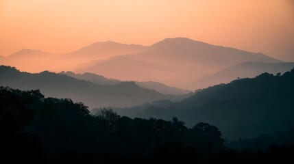 Obraz premium Misty mountains are bathed in a warm golden glow during the tranquil morning or evening light