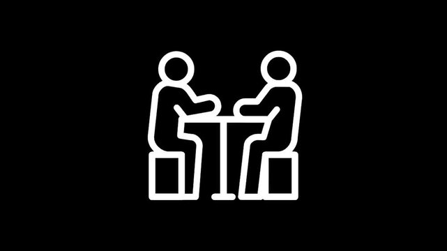 Two people sitting at a table, engaged in conversation or a meeting