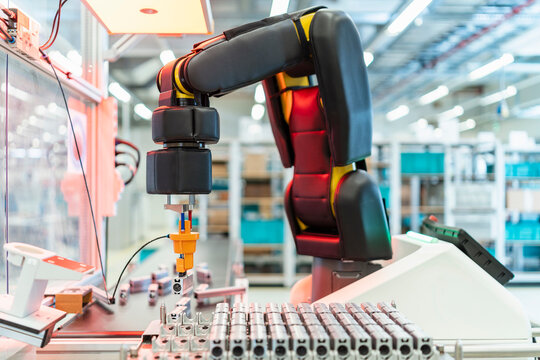 Arm of assembly robot picking up machine part, Stuttgart, Germany