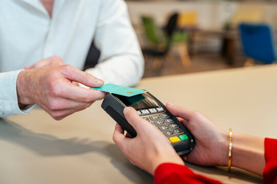 Customer making contactless payment with credit card at retail store