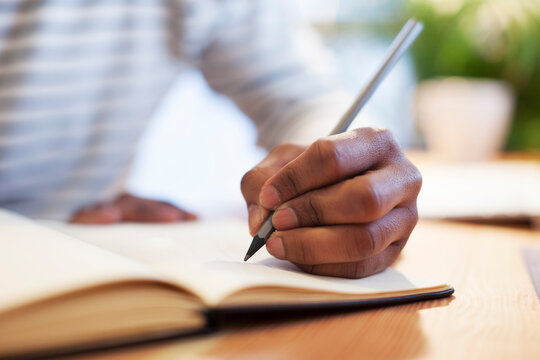 Man's hand drawing in a notebook