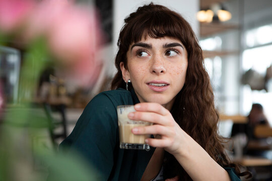 Portrait of young woman in a cafe looking around