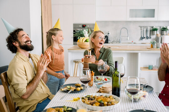 Family celebrating birthday with cake and laughter at home